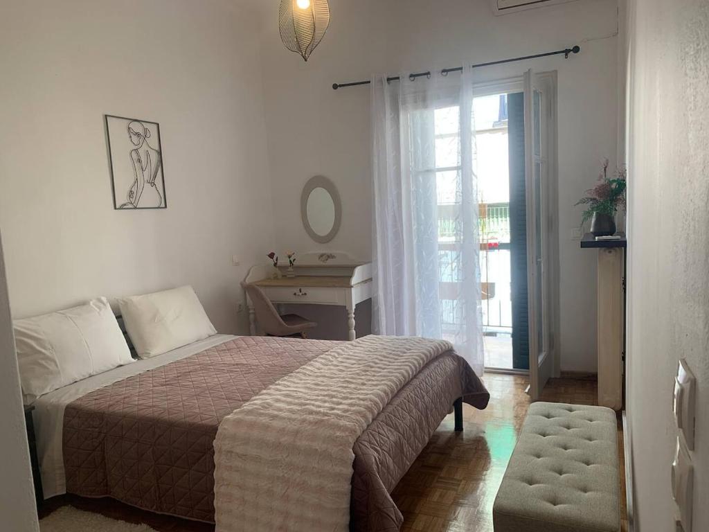 a bedroom with a bed and a table and a window at Athina Central Corfu Town Apartment in Ágios Rókkos