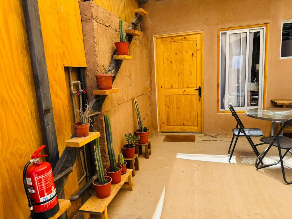 a room with a table and potted plants on the wall at Casa Ñawi in San Pedro de Atacama