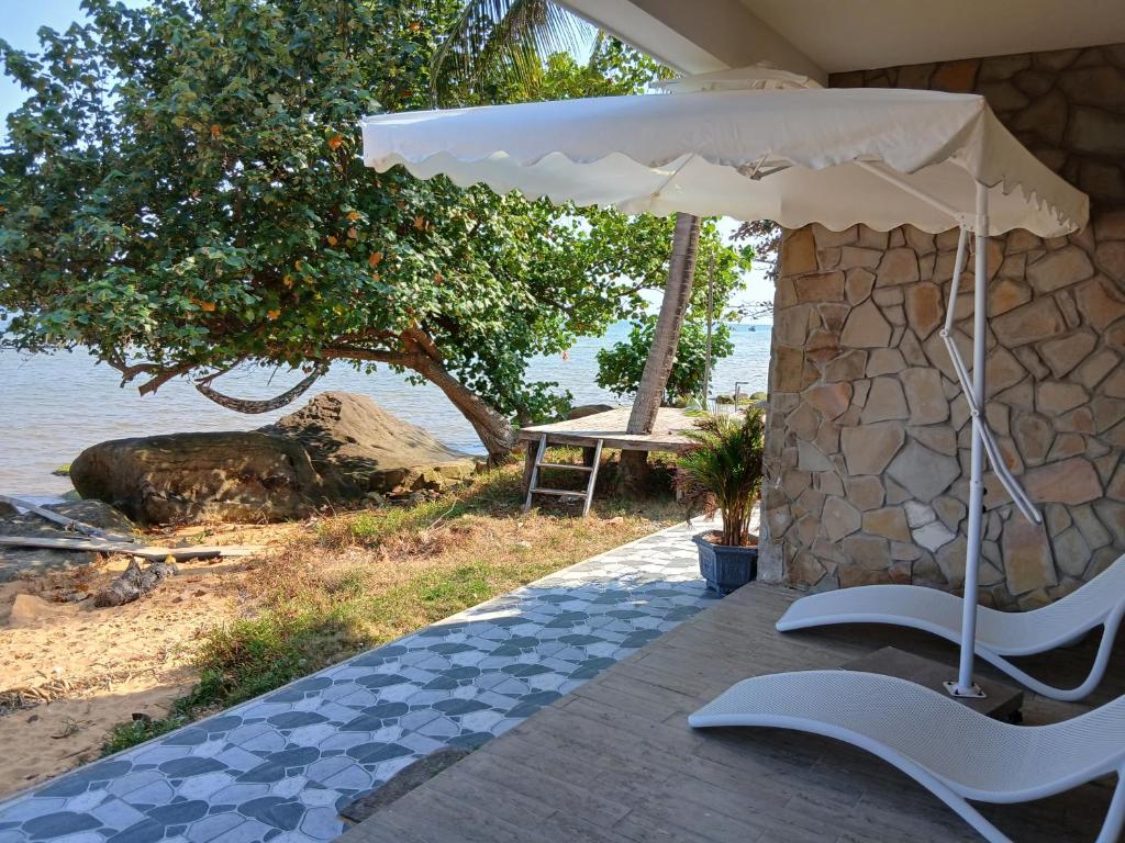 a patio with an umbrella next to the beach at OCEAN DREAM-Beach House in Phú Quốc