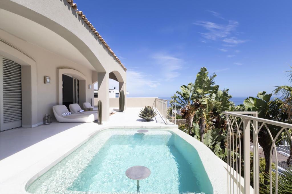 a villa with a swimming pool and a patio at Luxury 8-Suite Villa with Heated Pools, Ocean & Mountain Views in Cape Town