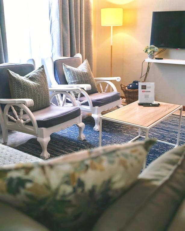 a living room with chairs and a coffee table at Summerville Place in Addo