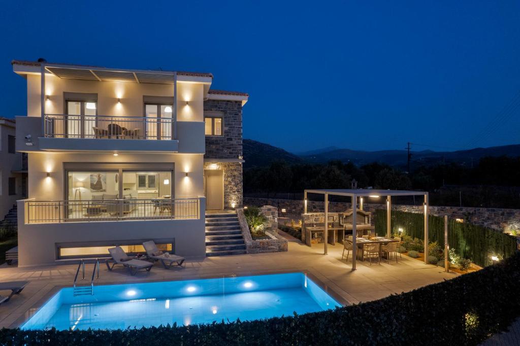 a villa with a swimming pool at night at Utopia Luxury Villas in Gouves