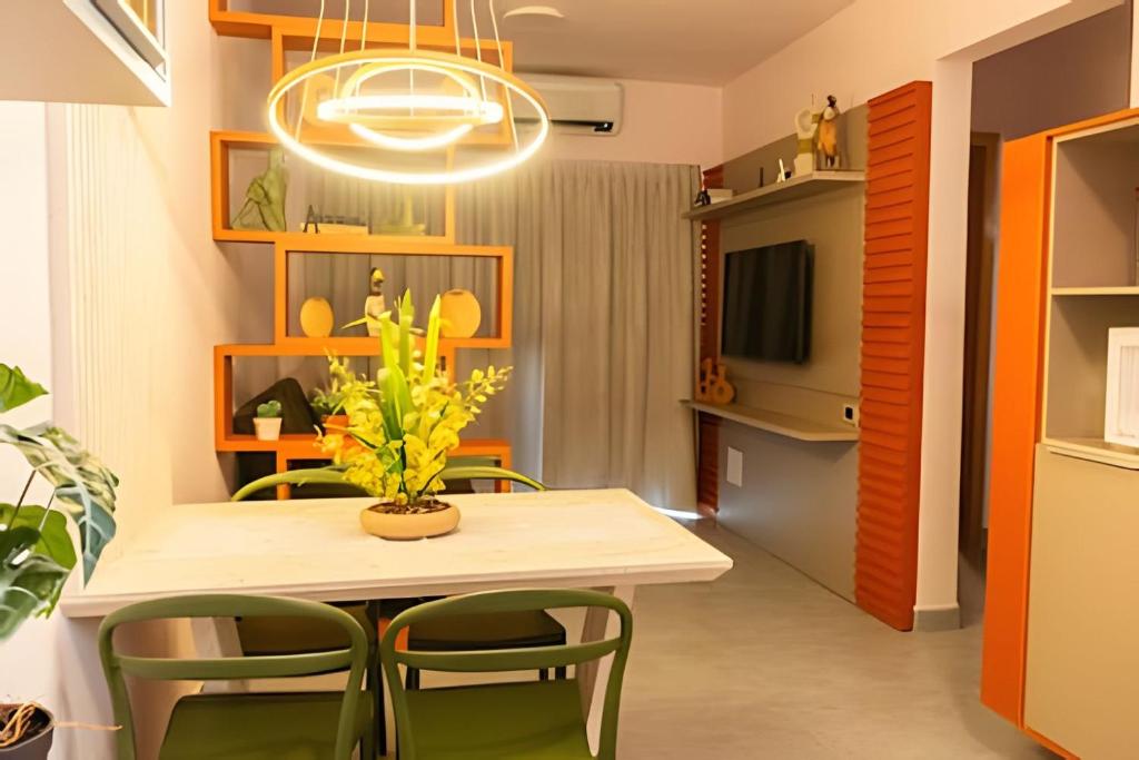 a dining room with a table and green chairs at Modernidade no Coração de Cuiabá in Cuiabá