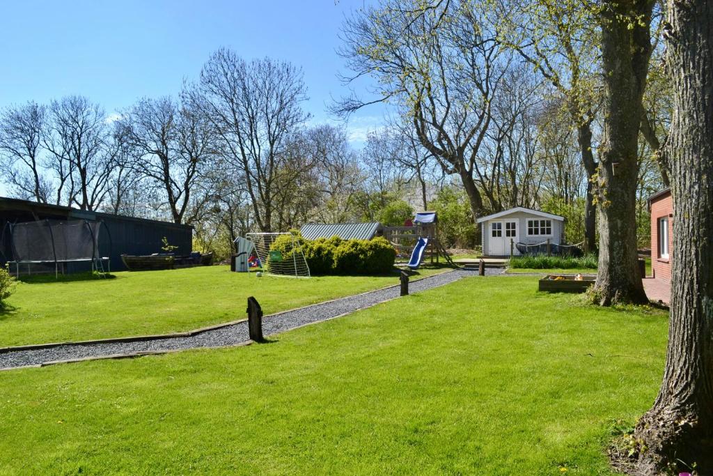 a yard with green grass and a house at Bauernhof-Steffens in Tating