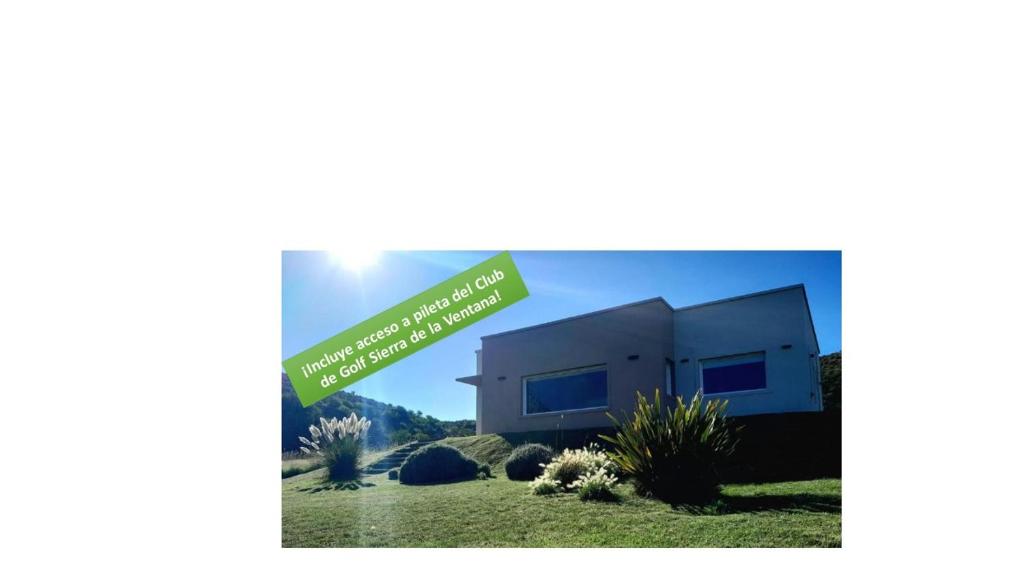 a house with a green sign in front of it at Lugar de PAZ en las Sierras in Sierra de la Ventana