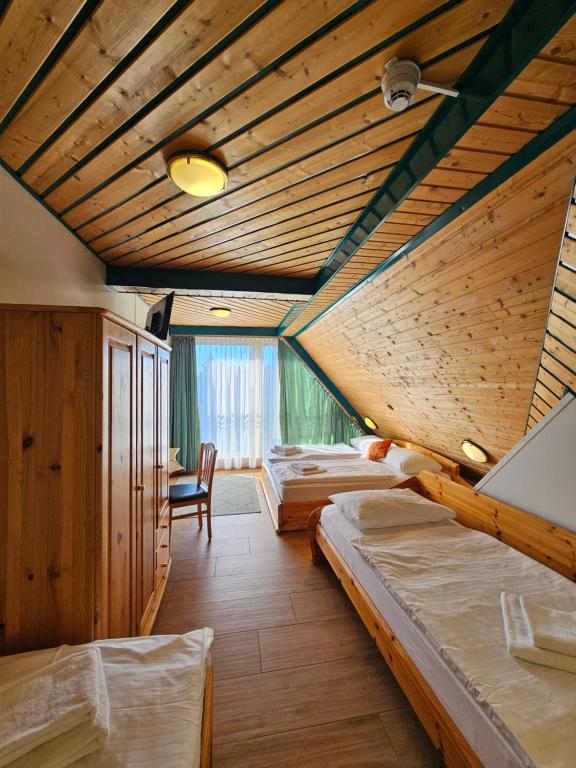a bedroom with four beds in a room with wooden ceilings at Hotel Asperner Löwe in Vienna