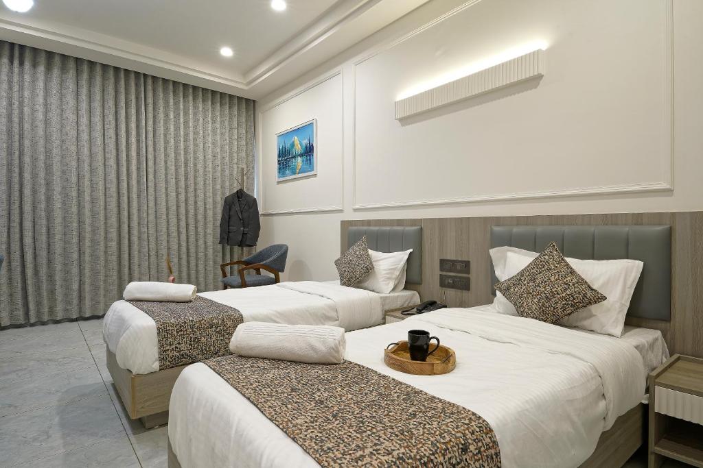 a hotel room with two beds and a chair at The Grand Platinum Hotel in Ahmedabad