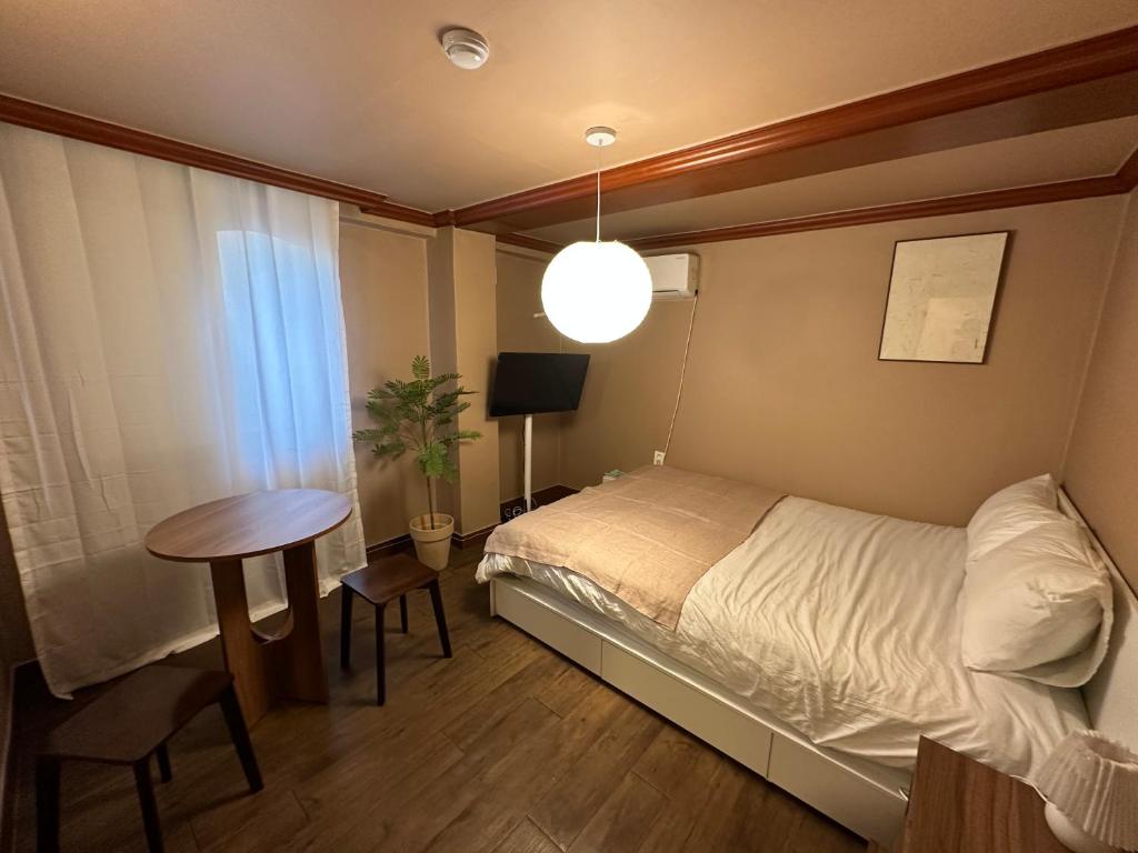 ein kleines Schlafzimmer mit einem Bett und einem Tisch in der Unterkunft 부일파크 in Suwon