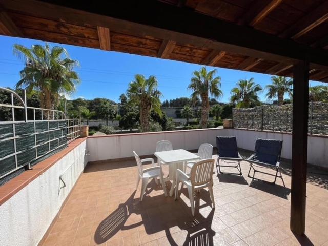 a patio with a table and chairs on a balcony at Sweet Summer House in Campofelice di Roccella