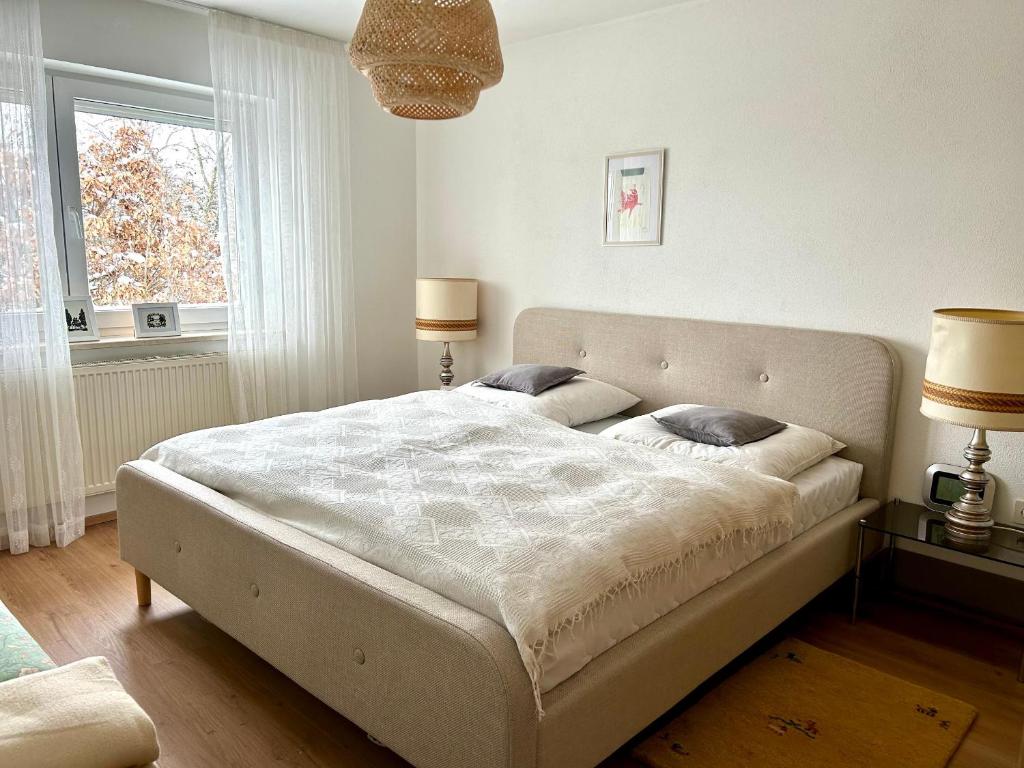 a bedroom with a bed with two lamps and a window at Ferienwohnung Bärbel in Freyung
