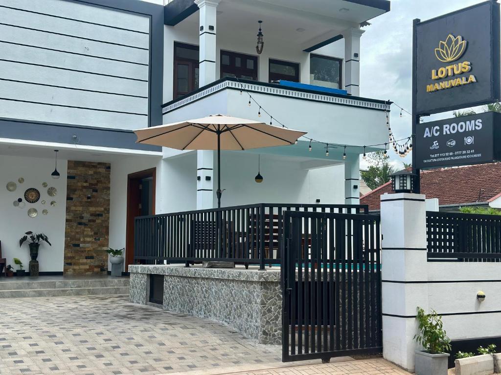 a building with an umbrella in front of it at Lotus Manuvala - Negombo in Kochchikade