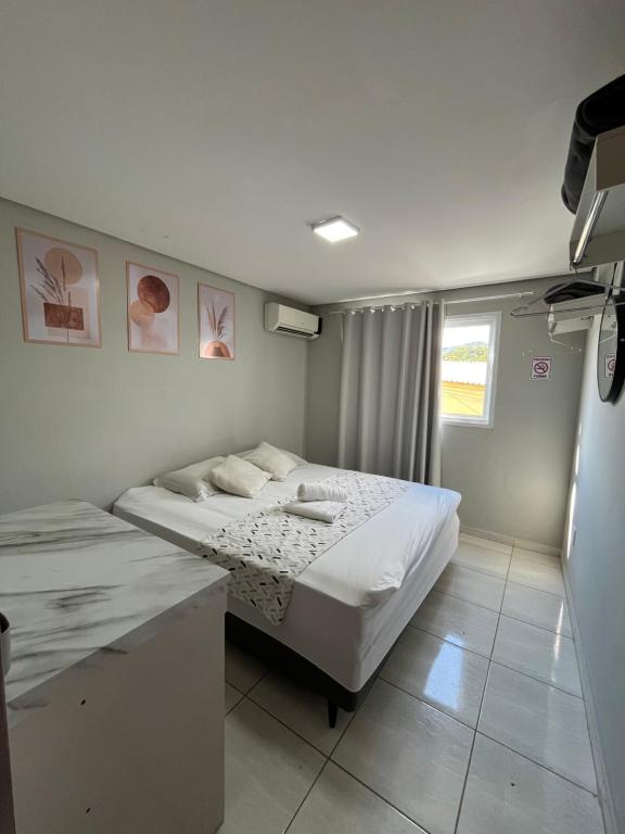 a bedroom with two beds and a desk in it at Casa Lua in Brumadinho