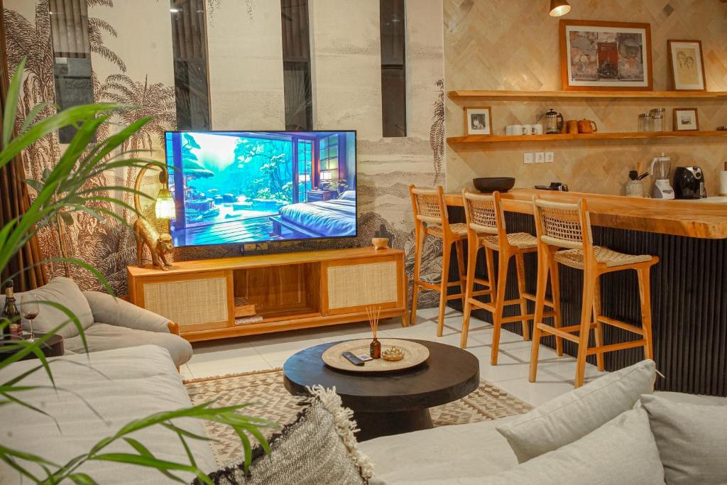 a living room with a tv and a bar at Homey Villa in Canggu