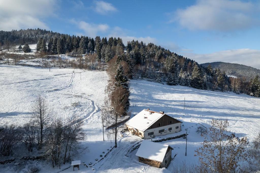 a house in a field with snow on it at La Ferme du Douanier & Spa 5 étoiles ALL INCLUSIVE in Ventron