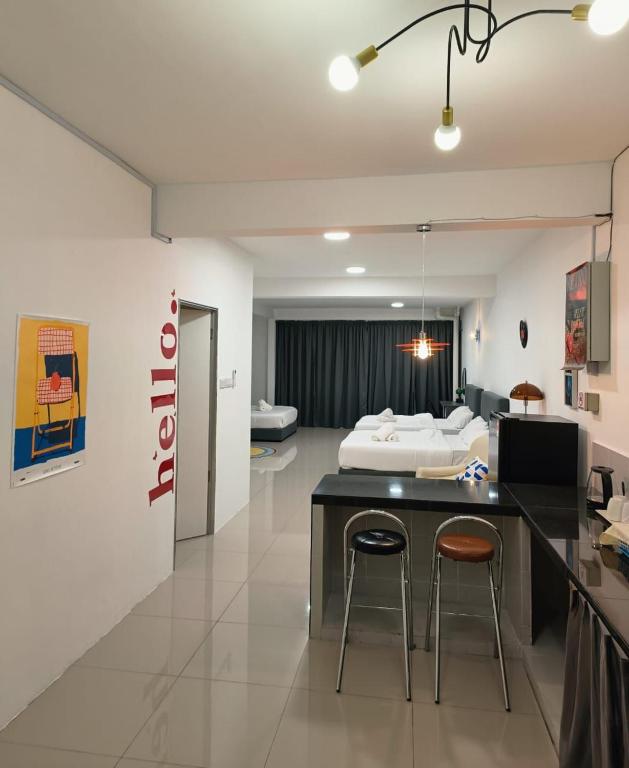 a hotel room with a bed and two bar stools at Gather inn in George Town