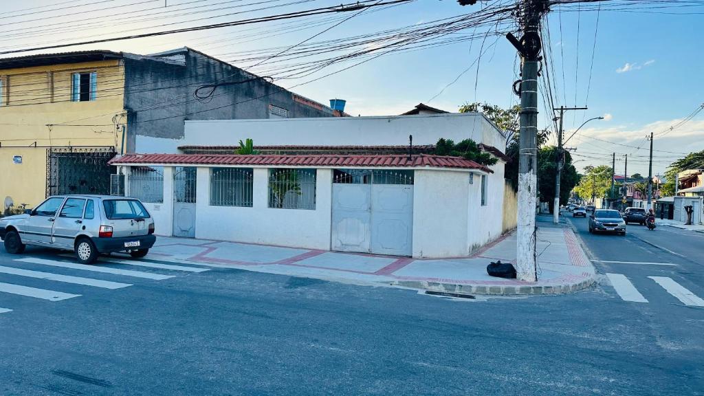 a white building on the corner of a street at Casa Jardim Colorado in Vila Velha