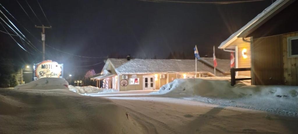 a house is covered in snow at night at Le Saint Alex in Saint-Alexis-des-Monts