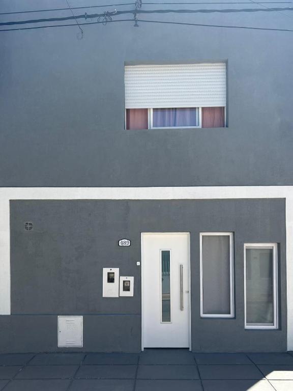 a building with two white doors and a window at El Nido FM in Concepción del Uruguay
