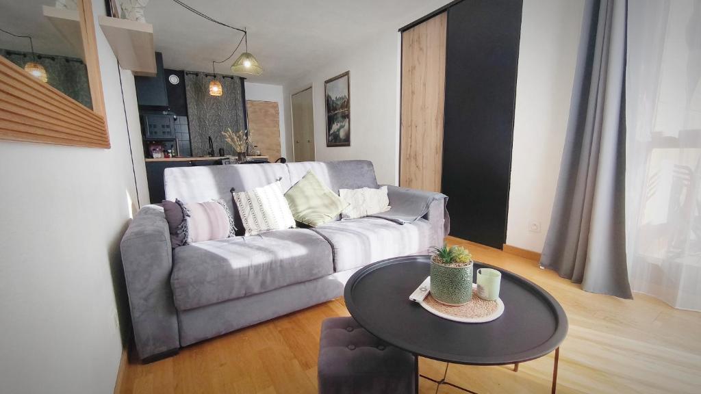 a living room with a couch and a table at Charmant Appartement Les temples du Soleil in Font-Romeu-Odeillo-Via