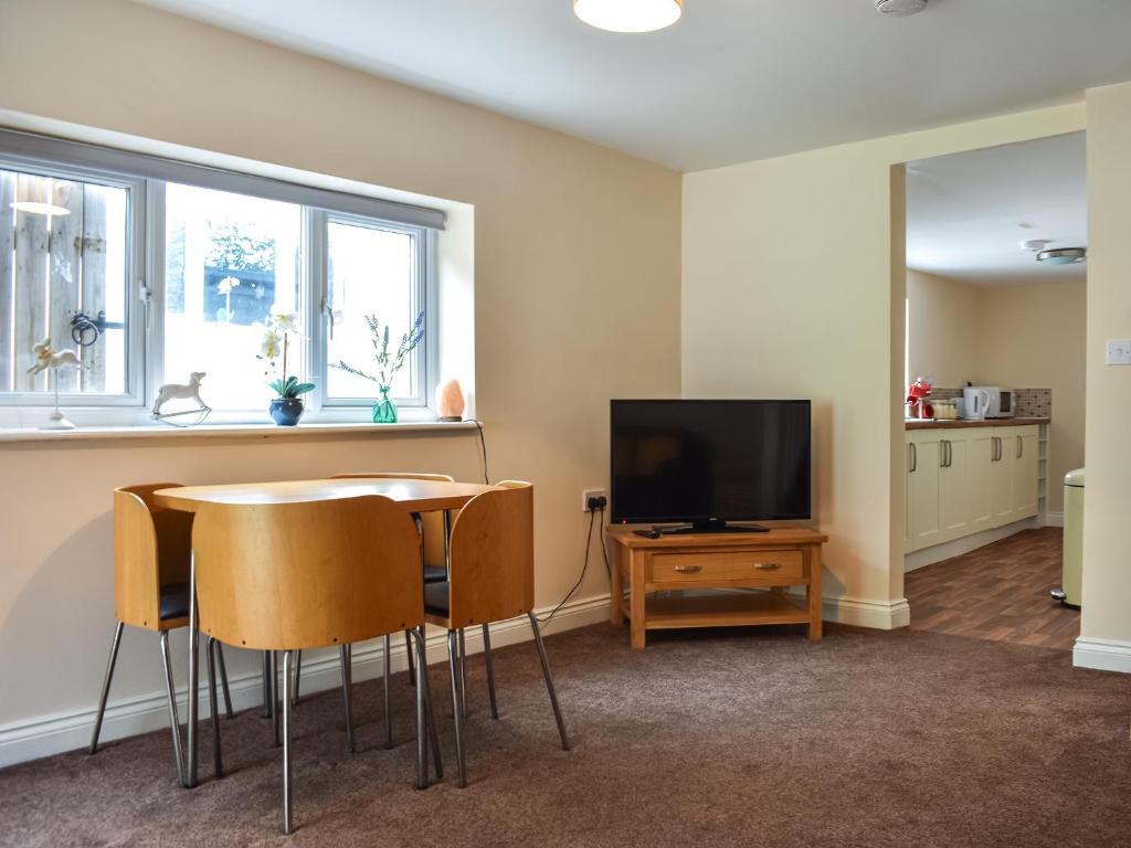 a living room with a table and a television at Winnies Cottage in Belford