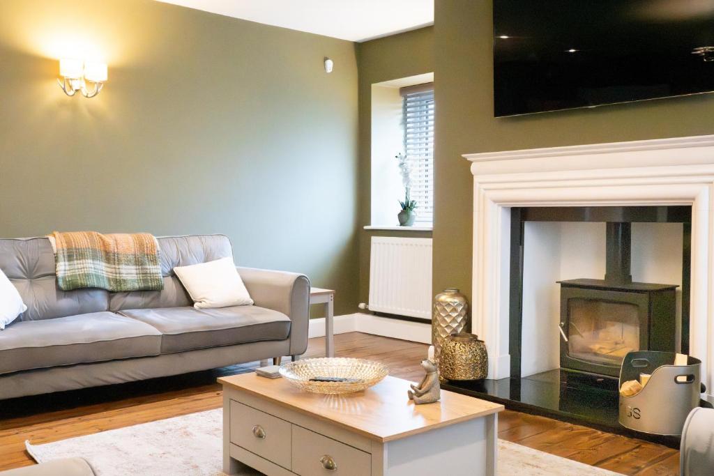 a living room with a couch and a fireplace at Northern Hideaways, Brown Bear House in Berwick-Upon-Tweed