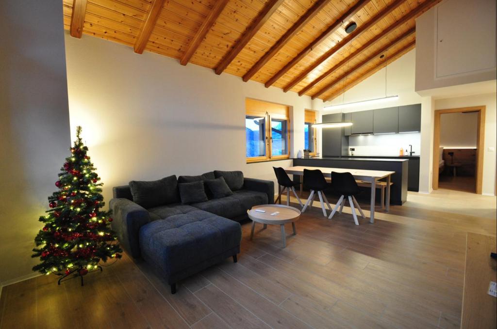 a living room with a christmas tree and a couch at Tossu, Haus Metropol B in Grächen