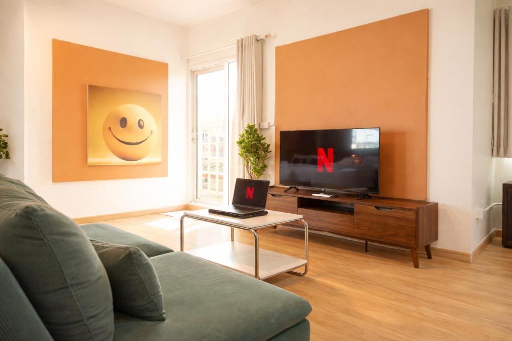 a living room with a couch and a tv at Samyan Story Boutique Hotel in Bangkok