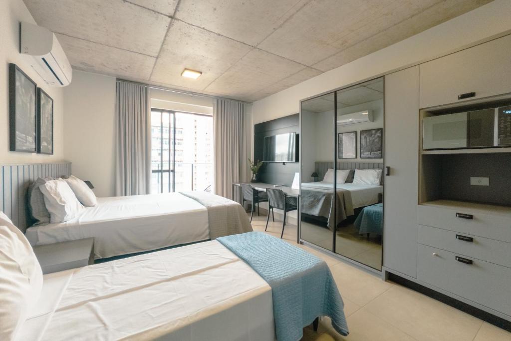 a hotel room with two beds and a television at Moderno e Central - CA905 in Maringá