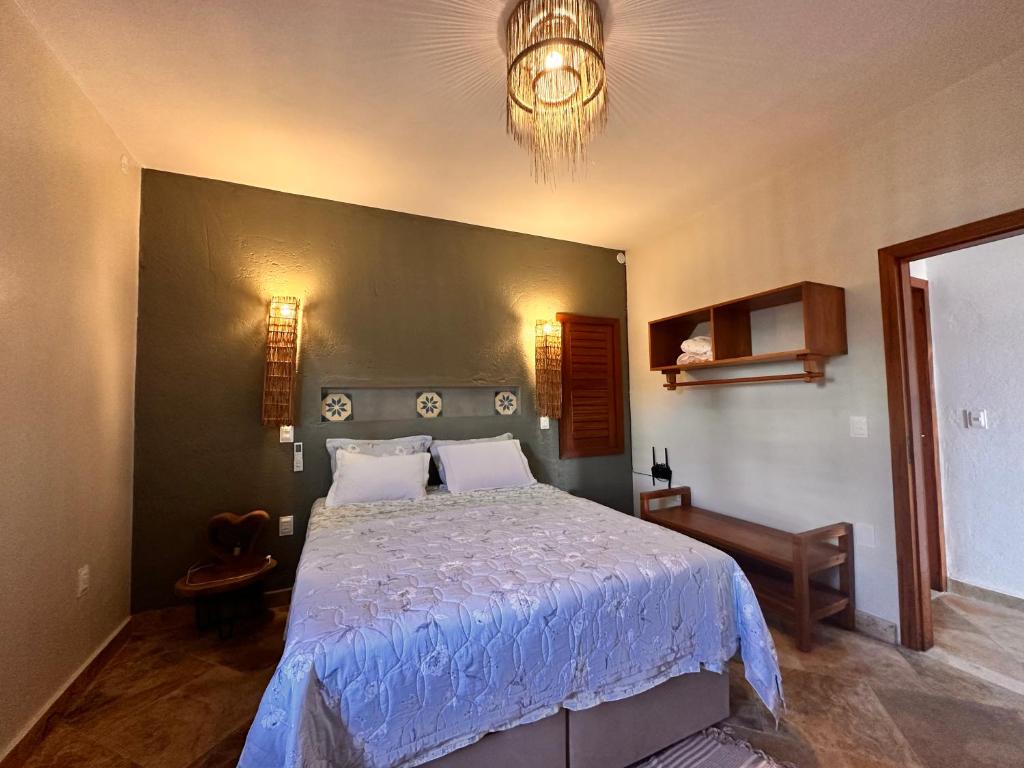 a bedroom with a large bed and a chandelier at casa nova in Cruz