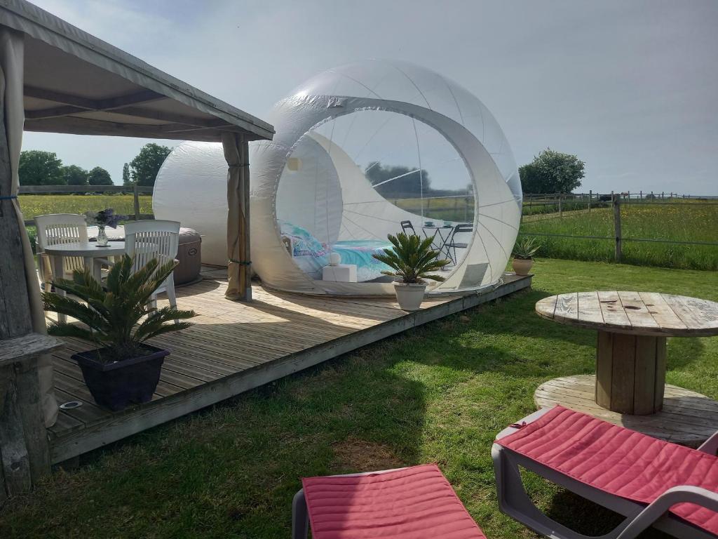 a backyard with a iguana tent and a table and chairs at La chevauchée vers les étoiles in Yèvres