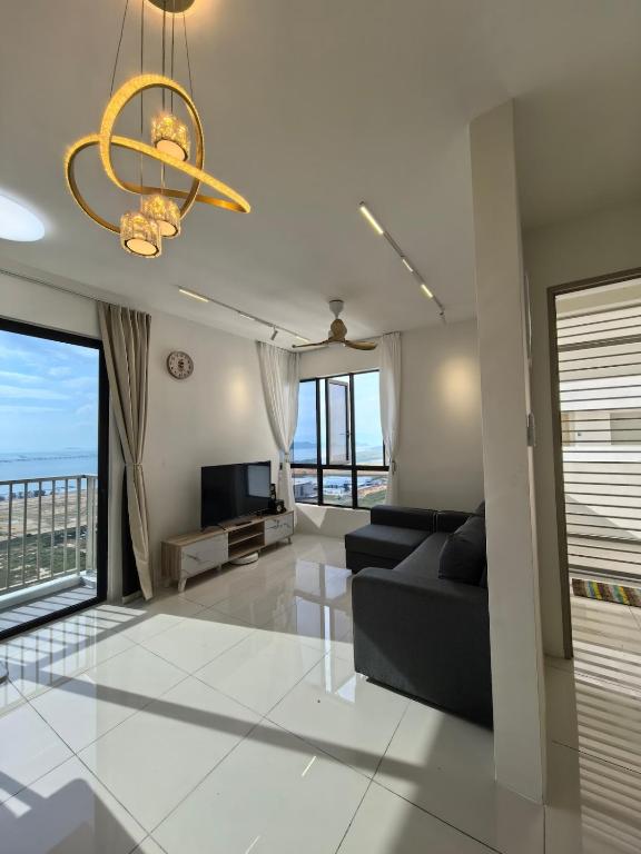 a living room with a couch and a television at Batu Kawan Sunset Seaview Condo near Ikea & Design Village in Batu Kawan