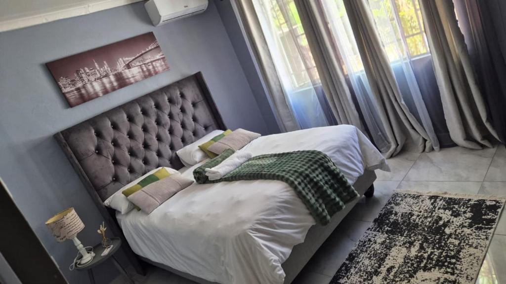 a bedroom with a bed with a headboard and a window at KeAnna STAYS units in Tsumeb