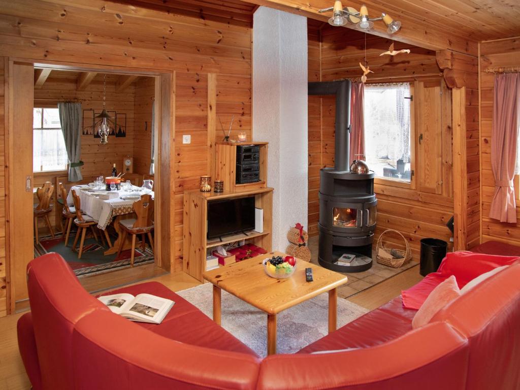 a living room with a table and a fireplace in a cabin at Chalet Kil-Ukru by Interhome in Ovronnaz