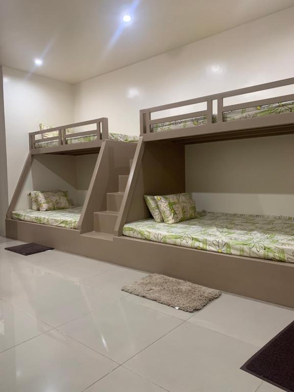 two bunk beds sitting in a room with a floor at PMPJ Cabin in Lipa