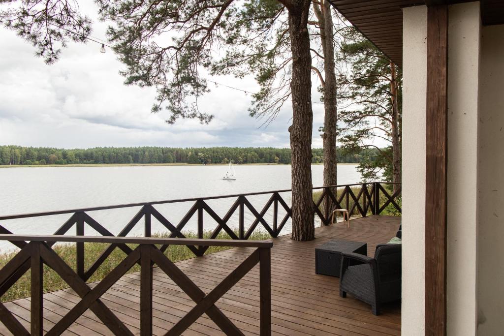 a wooden porch with a view of a lake at Przystań Kormoran in Czarna Wieś