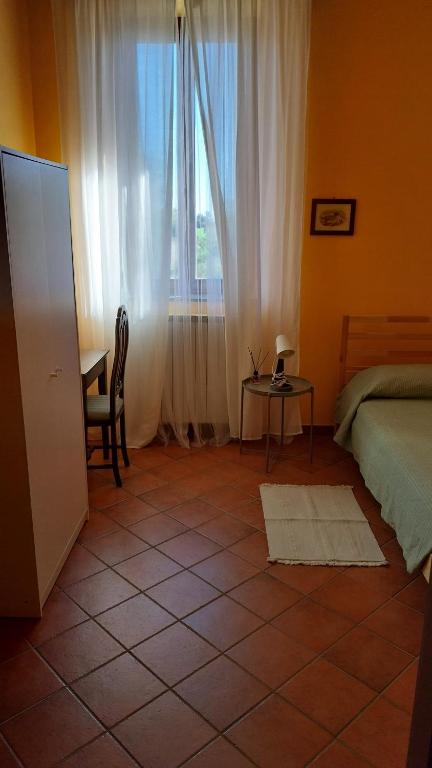 a bedroom with a bed and a table and a window at Tenuta Rio del Sole-Camera singola in Albairate