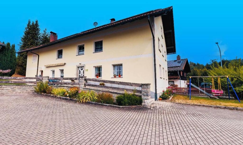 a white house with a playground in front of it at Haus Rita in Thurmansbang