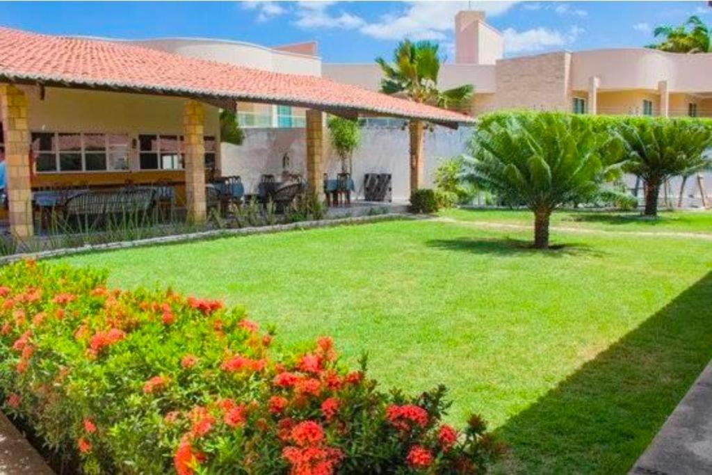 a yard in front of a house with flowers at Pousada Nosso Recanto Camocim in Camocim