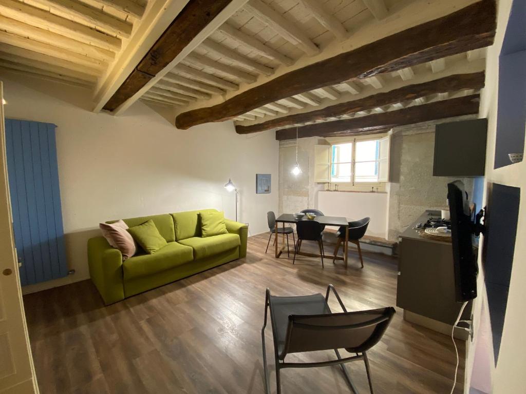 a living room with a green couch and a table at LuccaStay 99 in Lucca
