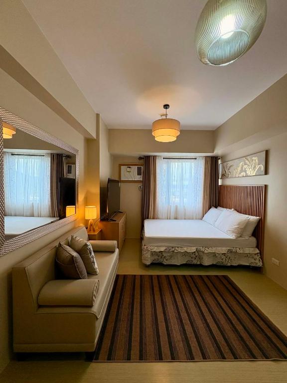 ein großes Schlafzimmer mit Bett und Sofa in der Unterkunft KBrothers - Chic Studio in the Heart of it All! in Cagayan de Oro