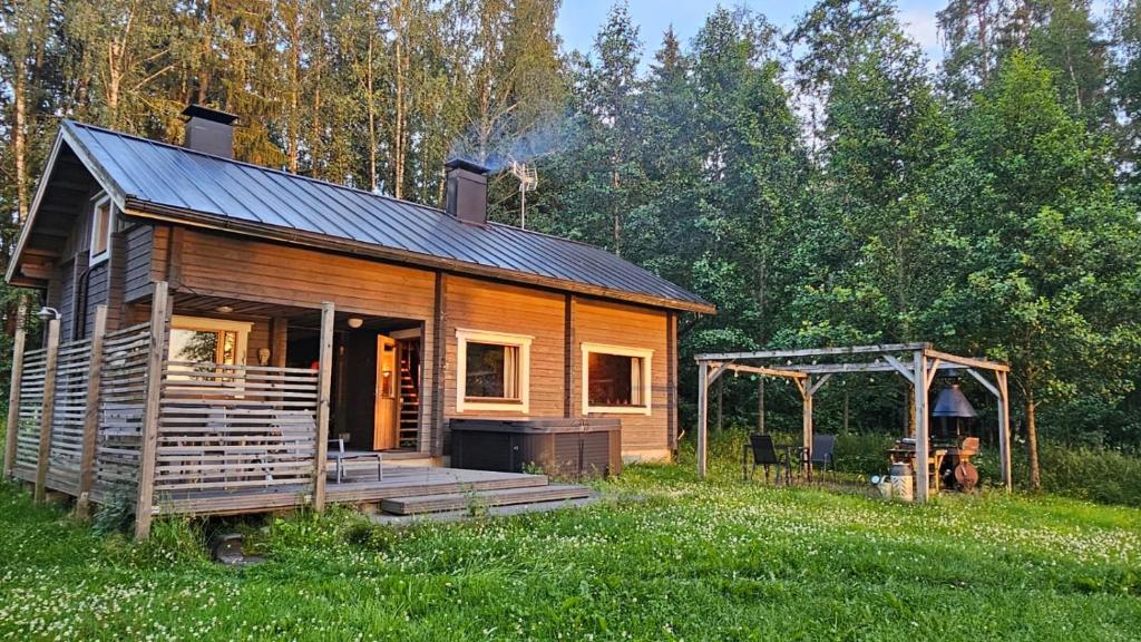 a log cabin with a porch and a gazebo at Authentic Finnish Lakeside Cottage in Lusila