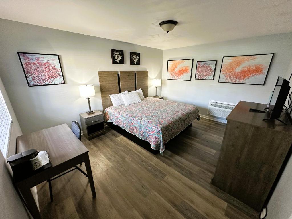 a hotel room with a bed and a table and a desk at Pirates Cove in Carolina Beach