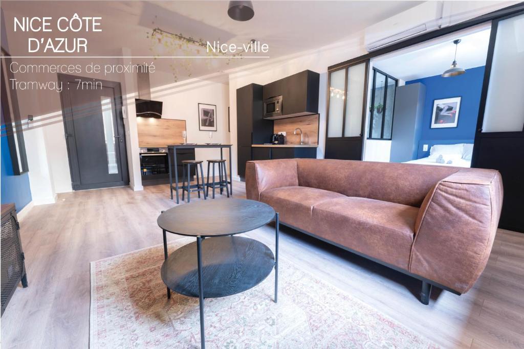 a living room with a couch and a table at Loft climatisé - proche de la mer - jacuzzi - Nice centre in Nice