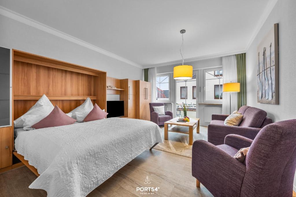 a hotel room with a bed and two chairs at Ferienwohnung Hummer Büsum in Büsum