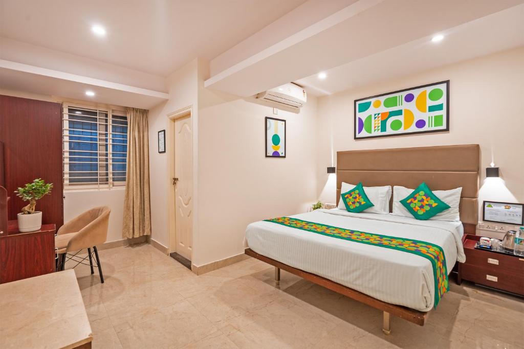 a hotel room with a bed and a desk and a room at Treebo Brixton Luxe in Bangalore