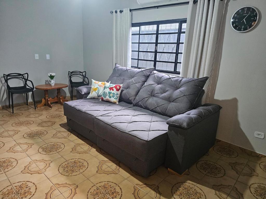 a couch in a living room with a window at Casa a 4 km do centro e Shopping Campo Grande in Campo Grande