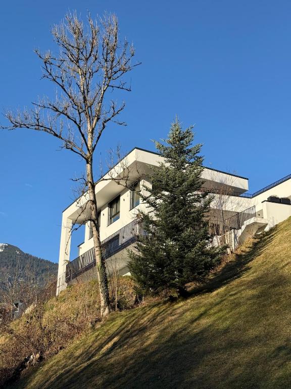 a building on top of a hill with a tree at Elcami Living in Fritzens