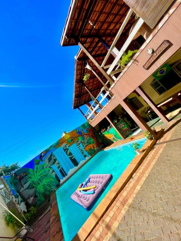 a resort with a beach with a paddle board on the sand at Hostel Park in Uberlândia