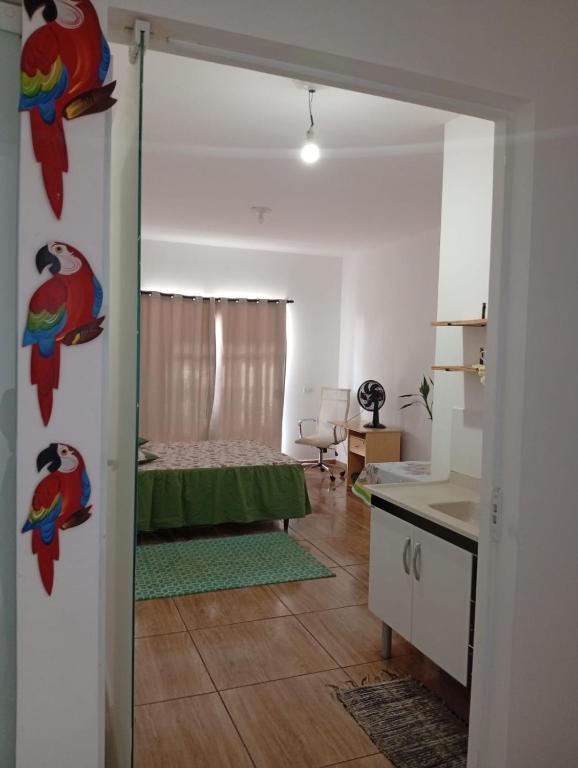 a living room with a bed and a kitchen at Kitnet Imigrantes in Holambra