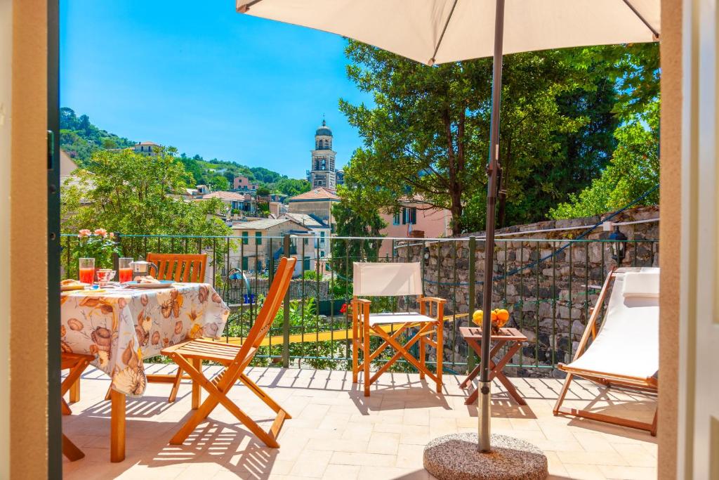 a patio with a table and chairs and an umbrella at PORTOVECCHIO Extra in Levanto